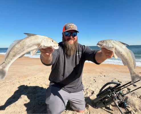 Ian from Tug Trash Outdoors carrying multiple fishing rods across a Florida beach using the Rod-Runner Portable Fishing Rod Caddy.